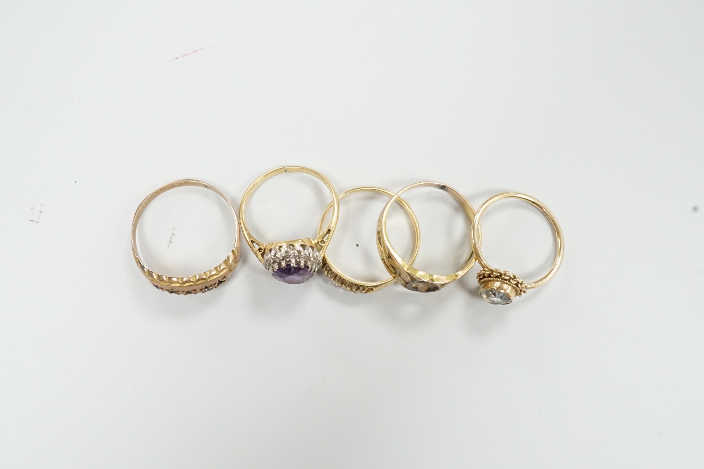 An 18ct, amethyst and diamond set oval cluster ring, size K and four other rings including gem set.